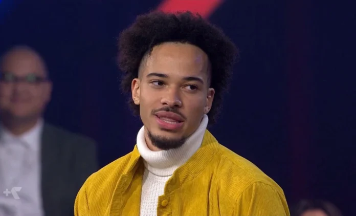 Marley Biyendolo on Australian TV wearing a yellow jacket and white turtleneck